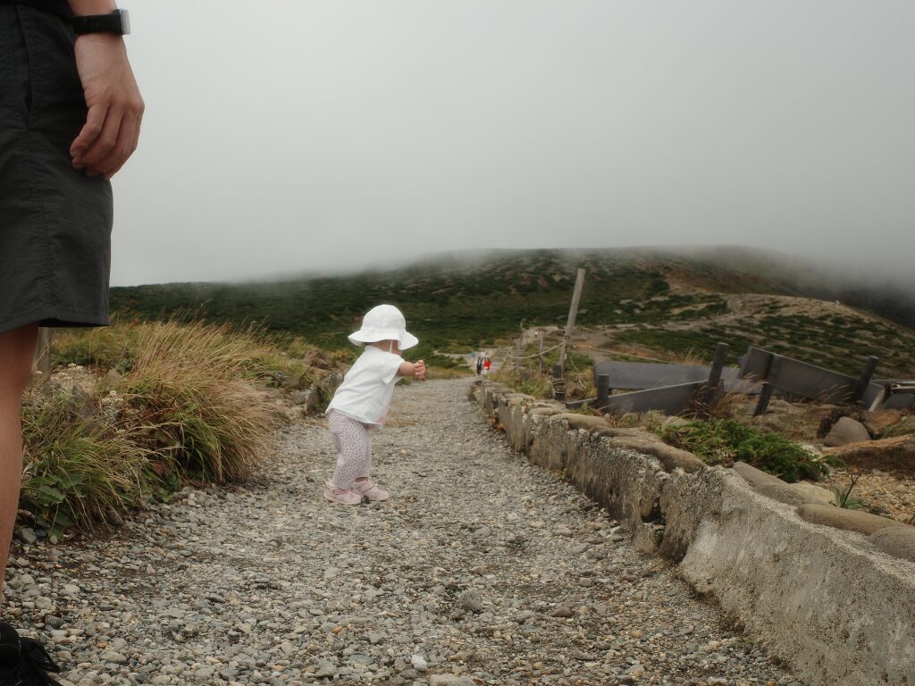 霧が濃い蔵王の御釜と歩く子供